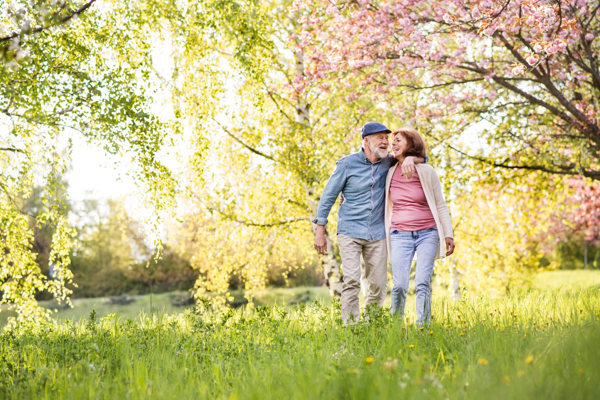 two seniors walking in a meadow