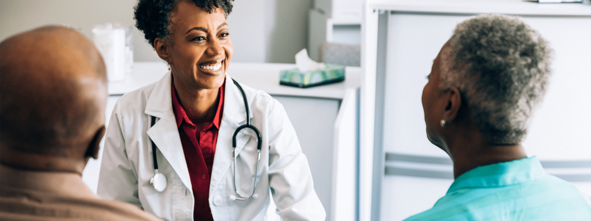 doctor chatting with patients in an examine room